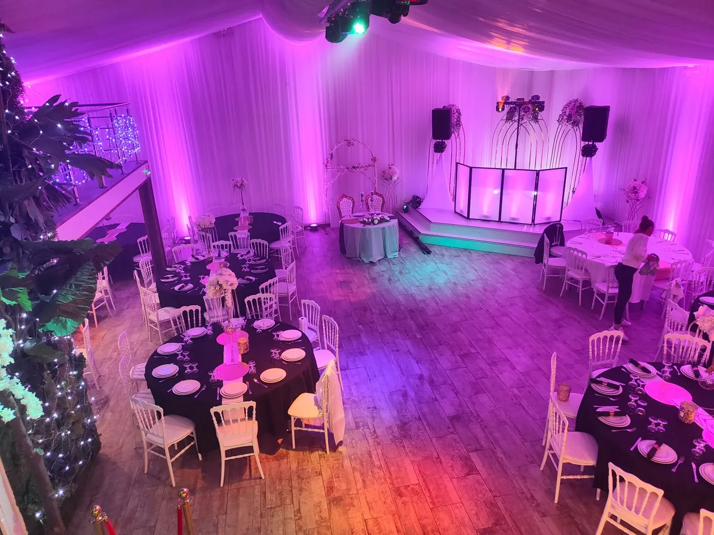 Salle de réception de mariage avec cabine DJ et éclairage d'ambiance