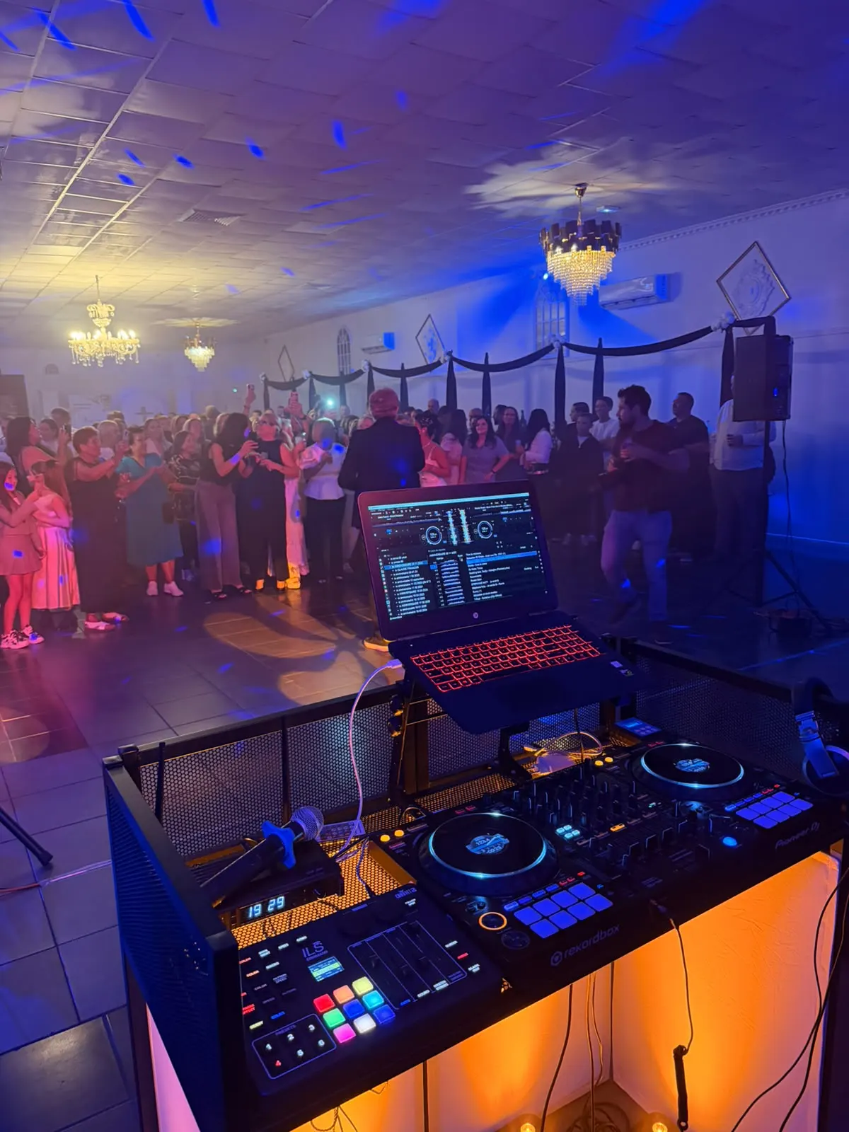 Poste DJ face à une salle de réception décorée
