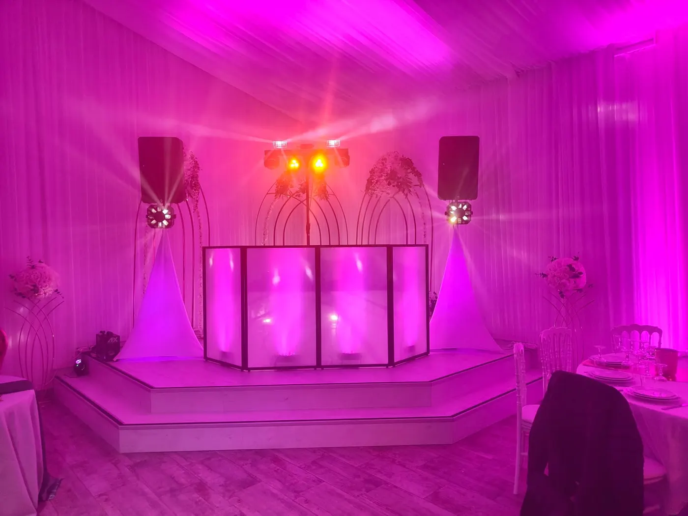 Cabine DJ blanche dans une salle drapée de rose
